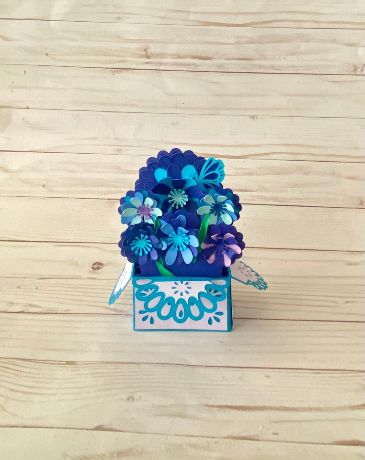 A popup-foldable greeting card that started it all. 7 different flower sizes that greet the recipient when opened with a custom greeting infant. this card is tones of blue.