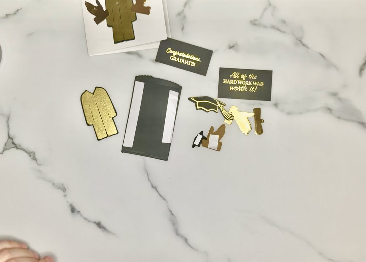 Graduation card pieces with adhesive backing, including a cap, diploma, and gift card holder