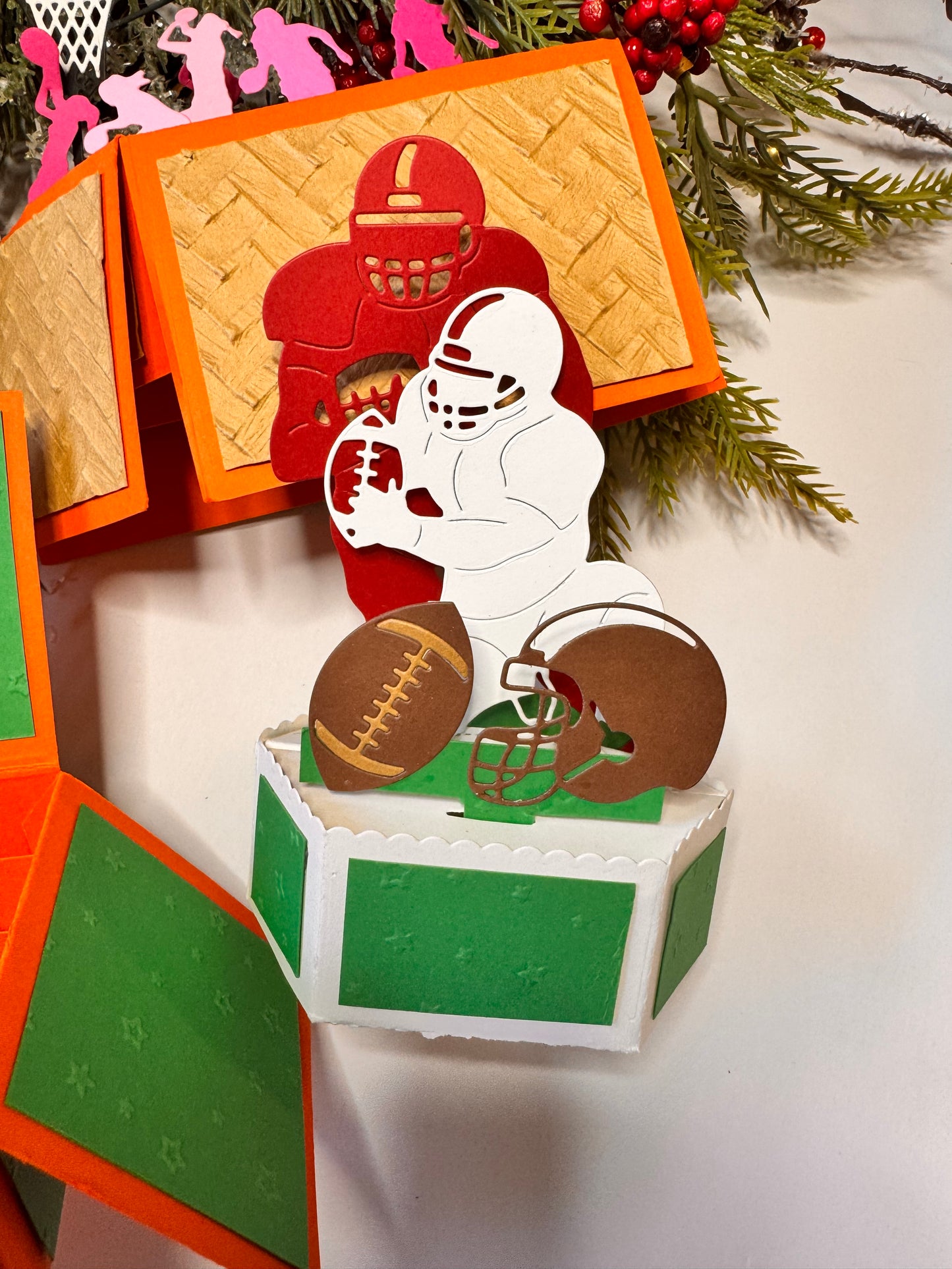 premade popup card taller football player with football all red, then white football player and football all white, brown football infront.